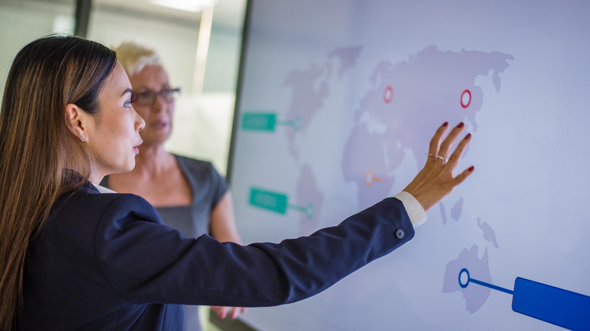 Businesswoman explaining technical graph to his coworker in conference room.