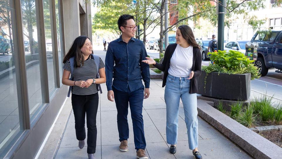 CU Denver students talking while walking on sidewalk in campus